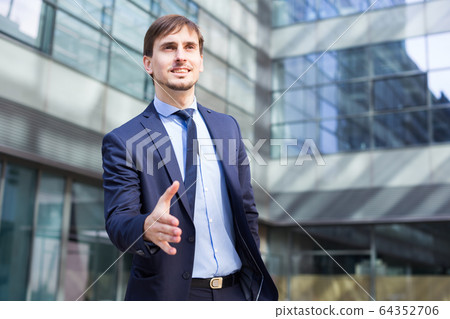 Smiling businessman standing outdoors Smiling businessman standing outdoors 64352706