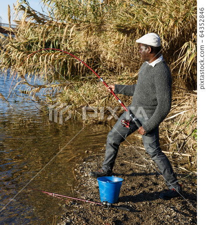 Man and pulling fish near river Man and pulling fish near river 64352846