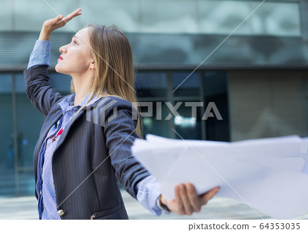 Professional woman in jacket working with documents 64353035