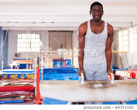 Man training on pommel horse Man training on pommel horse 64353192