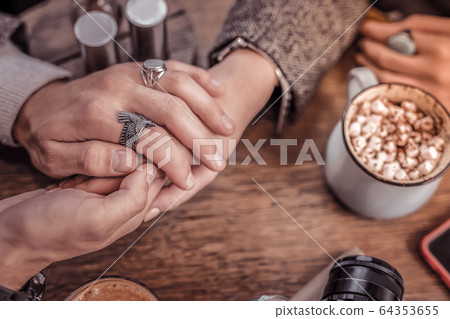 Cute photo of man and woman holding hands in cafe Cute photo of man and woman holding hands in cafe 64353655
