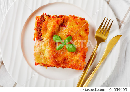 Meat cannelloni with fresh basil on top, close-up 64354405
