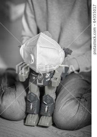 Boy plays with coronavirus protection mask and robot Boy plays with coronavirus protection mask and robot 64355017