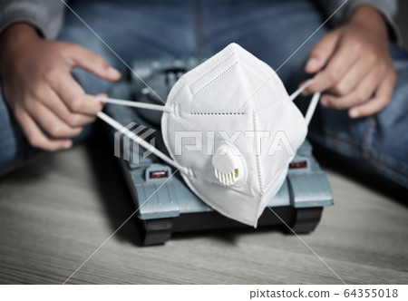 Boy plays with toys coronavirus symbols: toilet paper, medical gloves, protection mask 64355018