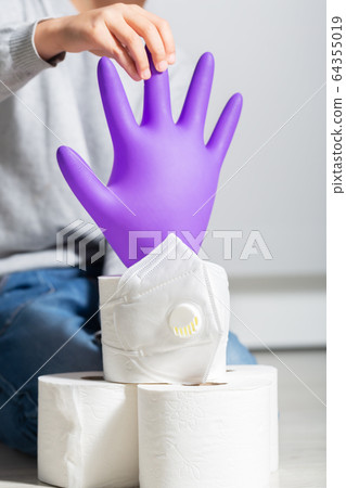 Boy plays with coronavirus symbols: toilet paper, medical gloves, protection mask Boy plays with coronavirus symbols: toilet paper, medical gloves, protection mask 64355019