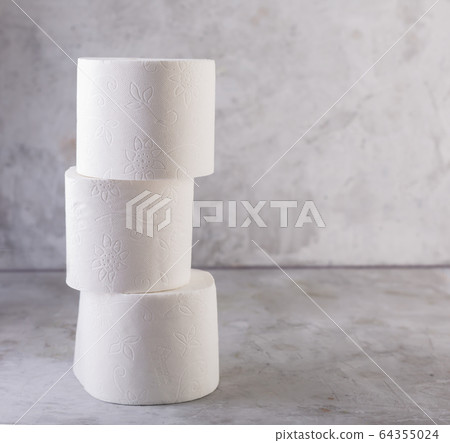 Toilet paper stacked rolls on a gray concrete background Toilet paper stacked rolls on a gray concrete background 64355024