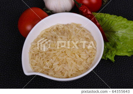 Raw uncooked rice in the bowl 64355643