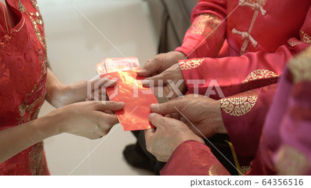 Giving red envelop for Chinese New Year Top view grandparent and five money to children Giving red envelop for Chinese New Year Top view grandparent and five money to children 64356516