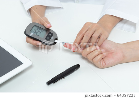 check diabetes. patient with diabetes let doctor put a drop of blood on a test strip into a meter for check blood sugar (glucose) levels results. health care concept check diabetes. patient with diabetes let doctor put a drop of blood on a test strip into a meter for check blood sugar (glucose) levels results. health care concept 64357225