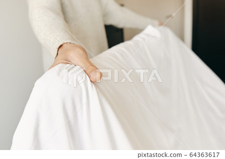 caucasian man making the bed 64363617