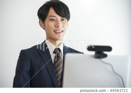 Image of a young man undergoing an online interview using a webcam 64363721