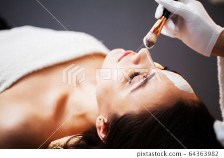 Woman getting spa face mask in beauty studio. Woman getting spa face mask in beauty studio. 64363982