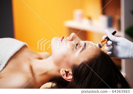 Woman getting spa face mask in beauty studio. Woman getting spa face mask in beauty studio. 64363983