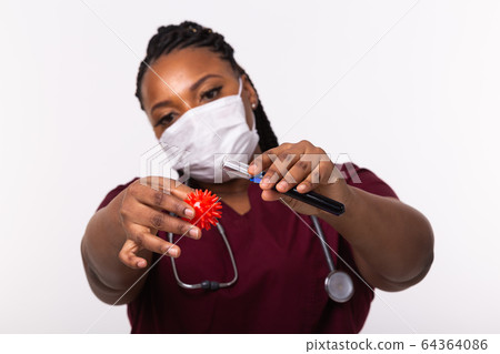 Covid-19, Vaccine development , outbreak and medicine concept - Doctor in medical protective mask holding a model of coronavirus and test tube on white background. 64364086