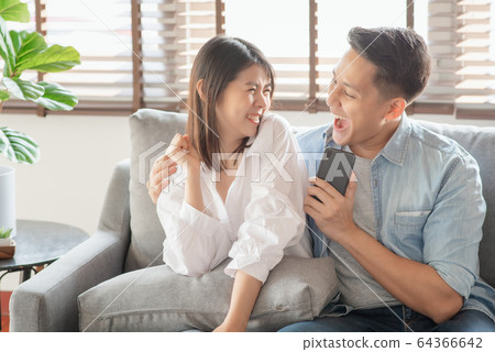 Asian couple lovers enjoy listening streaming online music via smartphone at home 64366642