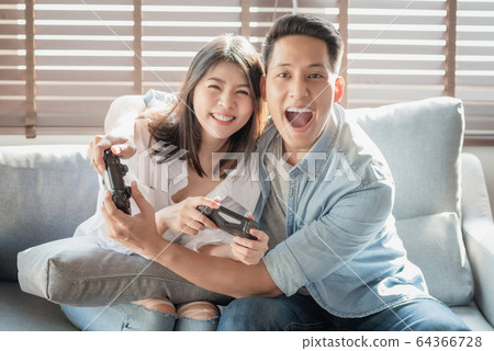 Asian couple lovers enjoy and play console game on vacation  64366728