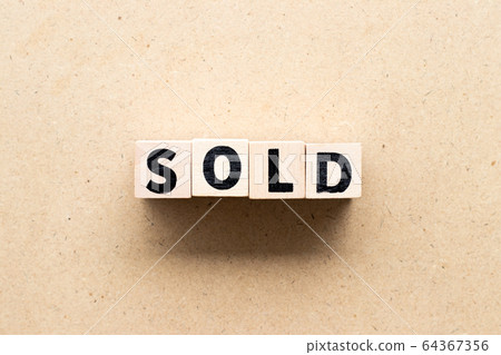 Letter block in word sold on wood background 64367356