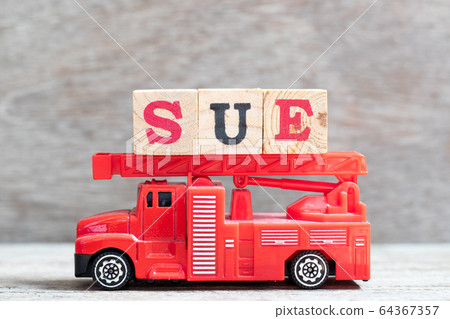 Red fire truck hold letter block in word sue on wood background 64367357