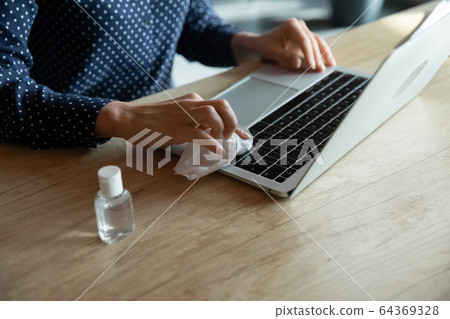 Close up of woman disinfect laptop with sanitizer Close up of woman disinfect laptop with sanitizer 64369328