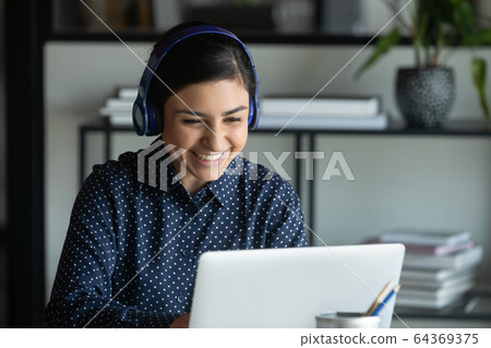 Smiling Indian woman have video call on laptop 64369375