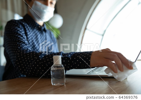 Close up of female disinfect laptop with gel sanitizer 64369376