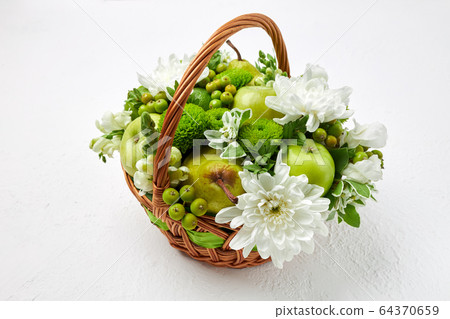 Wicker basket filled with fruits and flowers Wicker basket filled with fruits and flowers 64370659