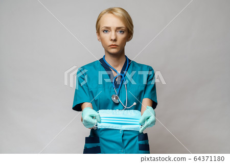 medical doctor nurse woman with stethoscope over light grey background - showing protective mask 64371180