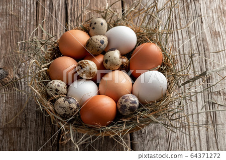 Hen and quail eggs in a wicker basket Hen and quail eggs in a wicker basket 64371272