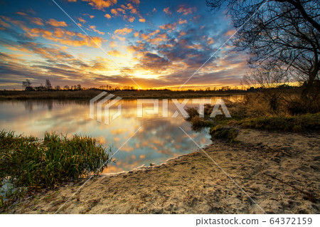 Beautiful sunrise over river banks 64372159