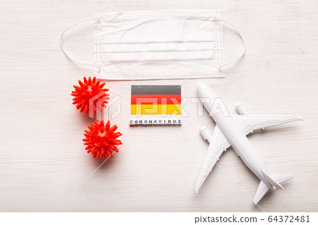 Plane model and face mask and flag Germany. Coronavirus pandemic. Flight ban and closed borders for tourists and travelers with coronavirus covid-19 from Europe and Asia. Plane model and face mask and flag Germany. Coronavirus pandemic. Flight ban and closed borders for tourists and travelers with coronavirus covid-19 from Europe and Asia. 64372481