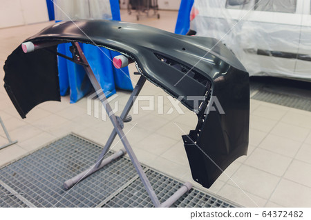 Auto mechanic preparing the car for paint job by applying polish with the power buffer machine Auto mechanic preparing the car for paint job by applying polish with the power buffer machine 64372482