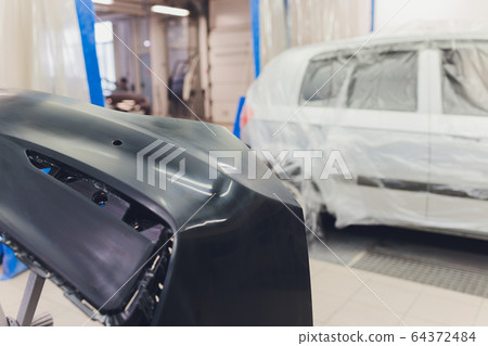 Auto mechanic preparing the car for paint job by applying polish with the power buffer machine Auto mechanic preparing the car for paint job by applying polish with the power buffer machine 64372484