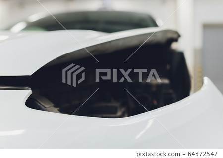 Mechanic in autoservice installing a headlamp to a car. car headlight repair. background image for auto service article. 64372542