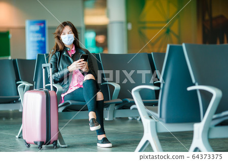 Young tourist woman with baggage in international airport Young tourist woman with baggage in international airport 64373375