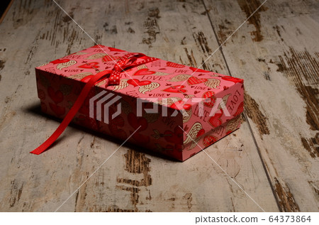 Gift box on a wooden table for Valentines day. 64373864