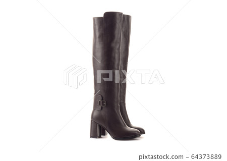 Female Legs in Classic Black and White Sneakers. Legs are Raised Upwards and Dangle from Side to Side. Grey Background. Classic Shoes. Healthy Lifestyle 64373889