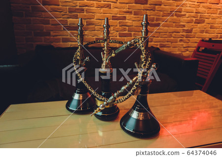 Stylish wooden hookah in the evening on a summer terrace in a cafe. Stylish wooden hookah in the evening on a summer terrace in a cafe. 64374046