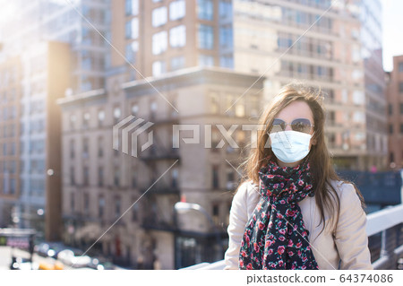Young woman walks in empty New York in a mask protecting from the virus Young woman walks in empty New York in a mask protecting from the virus 64374086