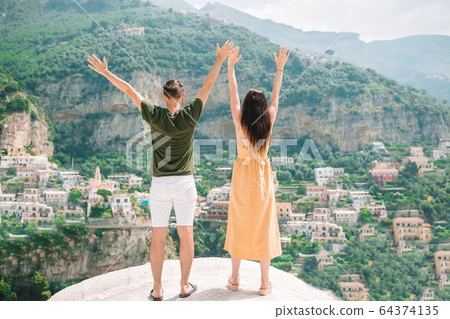 Summer holiday in Italy. Young man and woman in Positano village on the background, Amalfi Coast, Italy Summer holiday in Italy. Young man and woman in Positano village on the background, Amalfi Coast, Italy 64374135