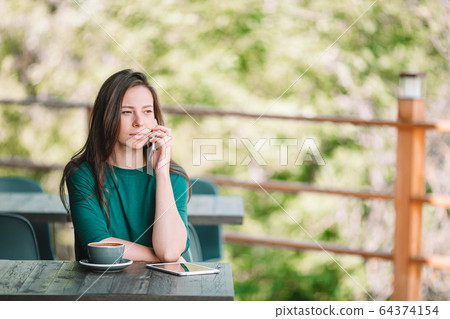 Beautiful woman works from home on terrace Beautiful woman works from home on terrace 64374154