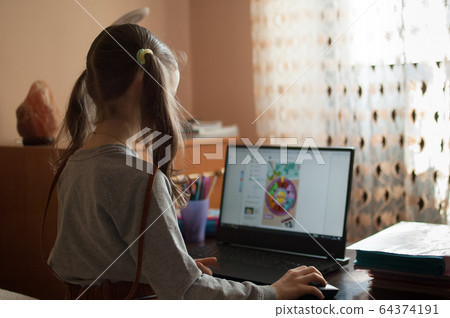 Back view of little girl with two ponytails sitting in front of the screen of her black laptop and studying at home because of the self-isolation due to Coronavirus Covid-19. Remote education Back view of little girl with two ponytails sitting in front of the screen of her black laptop and studying at home because of the self-isolation due to Coronavirus Covid-19. Remote education 64374191