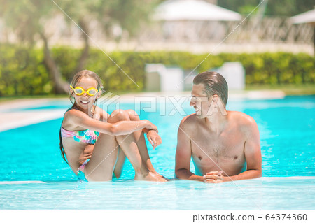 Family of mom and little daughter enjoying summer vacation in luxury swimming pool 64374360