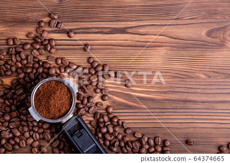 Roasted coffee beans and a porta filter. Roasted coffee beans and a porta filter. 64374665