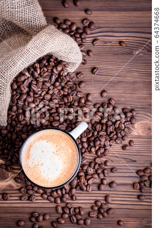 White coffee cup on a dark background of roasted beans. White coffee cup on a dark background of roasted beans. 64374668