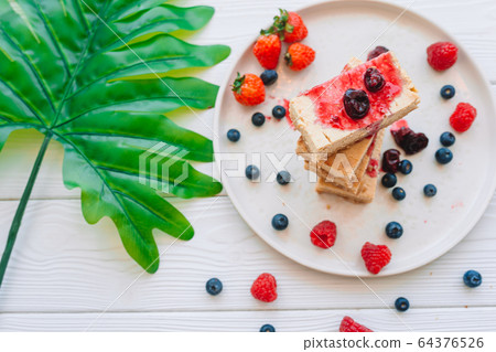 Slice of classic cheesecake with fresh berries on the white plate - healthy organic summer dessert. 64376526