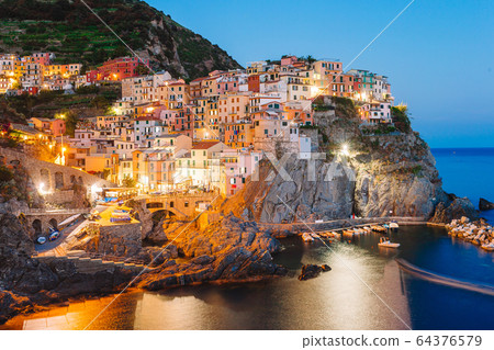 Stunning view of the beautiful and cozy village of Manarola in the Cinque Terre Reserve at sunset. Stunning view of the beautiful and cozy village of Manarola in the Cinque Terre Reserve at sunset. 64376579