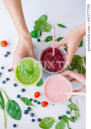 Row of healthy fresh fruit and vegetable smoothies with assorted ingredients Row of healthy fresh fruit and vegetable smoothies with assorted ingredients 64377709