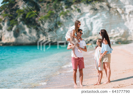 Young family of four on beach vacation Young family of four on beach vacation 64377790
