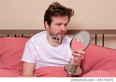 young man looking on mirror looking on his long young man looking on mirror looking on his long 64378076