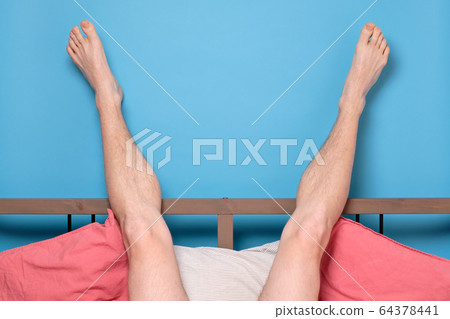 man legs resting in quarantine at bed at home. 64378441